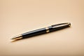 A black pen with gold trim sits on a gray surface Royalty Free Stock Photo