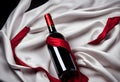 Bottle of red wine and flutters of red cloth on a black background