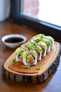 Fresh Avocado And Vegetable Sushi Rolls Served On Rustic Wooden Slice Board With Natural Light Royalty Free Stock Photo