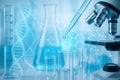 AI generated close up of pipette dropping liquid into glass test tubes with microscope and molecular graphics in modern science Royalty Free Stock Photo