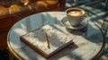 A cozy coffee cup and journal on a marble table with warm lighting.