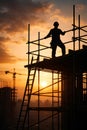 Construction Worker Silhouette Standing On Scaffolding Against Sunset Sky Royalty Free Stock Photo