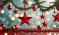 A red star ornament is hanging from a tree branch.