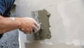 Worker plastering a wall with a spatula, closeup AI generated