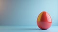 A glossy, red egg-shaped object is placed on a smooth, light blue surface with a matching blue background Royalty Free Stock Photo