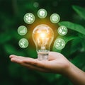 AI Generated Hand Holding Glowing Lightbulb Surrounded by Ecological Symbols Royalty Free Stock Photo