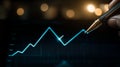 A hand holds a pen near a glowing, fluctuating line graph displayed on a screen