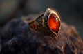 AI-generated illustration of a beautiful ring with a red stone placed on a rock surface Royalty Free Stock Photo