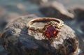 AI-generated illustration of a beautiful ring with a red stone placed on a rock surface Royalty Free Stock Photo