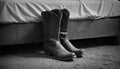 Two worn cowboy boots sit by a bed in a western cabin. Rustic scene. Royalty Free Stock Photo