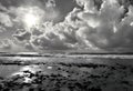 black and white photograph of a sky filled with clouds and water