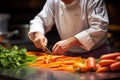 a chef slicing carrots in front of a pile of greens Royalty Free Stock Photo