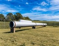 an industrial pipe in the field with trees and grass around it