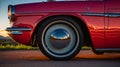 the tire wheel on an old red car is shown at sunset