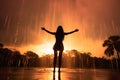 the silhouette of a woman who is standing in a fountain