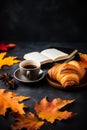 AI generated illustration of coffee, croissants, and autumn leaves arranged on a black background