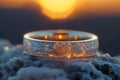 AI generated illustration of a diamond wedding ring illuminated by sunlight on a snowy surface Royalty Free Stock Photo