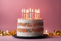 birthday cake with white frosting and lit candles against a pink background Royalty Free Stock Photo