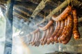 AI generated illustration of homemade sausages hanging to dry in a traditional smokehouse