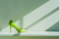 AI-generated illustration of a lime-colored high heel shoe on a ledge