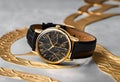 A luxurious gold and black wristwatch elegantly showcased on a sleek marble surface