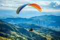 the man is parasailing in the blue sky over the mountains Royalty Free Stock Photo