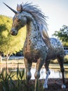 AI generated illustration of a metallic statue of a horse, standing in near a pond