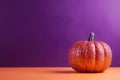 AI generated illustration of an orange glittered pumpkin in front of a purple background