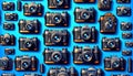 lots of old and new black cameras against a blue background