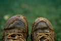 AI generated illustration of a pair of worn-out shoes covered in dirt and mud