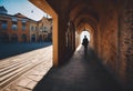 a person walking down an alley way near some buildings and cars Royalty Free Stock Photo