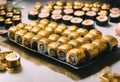 AI generated illustration of a plate with assorted pieces of sushi with golden flakes