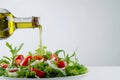 a person pouring olive into a bowl filled with fresh salad Royalty Free Stock Photo