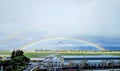 a rainbow appears to overwash the city and a plane Royalty Free Stock Photo