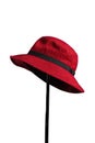 AI generated illustration of a red fedora with a black band displayed on a hat rack Royalty Free Stock Photo