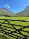 AI generated illustration of a rustic wooden fence stretching across a meadow, with mountains Royalty Free Stock Photo