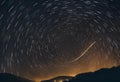 AI generated illustration of a star trail arching over a mountain range with the Pacific Ocean