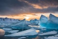 icebergs floating on the ocean at sunrise with a small mountain in the background