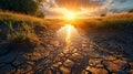 the sun rising over cracked land and water running through it Royalty Free Stock Photo