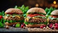 three hamburgers on buns covered in lettuce, tomatoes and cheese Royalty Free Stock Photo