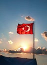 AI generated illustration of the Turkish flag fluttering in the wind, illuminated by the sunset Royalty Free Stock Photo