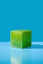 AI generated illustration of a vibrant green cube on a bright blue background