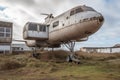 AI generated illustration of a vintage aircraft parked on a grassy field near a brick building Royalty Free Stock Photo