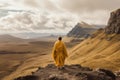 AI generated illustration of a wonk in a bright yellow gown on a rocky mountain on a cloudy day