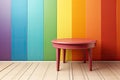 A wooden stool with a rainbow-colored wall, with space for text