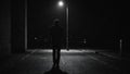 a person standing at the end of an empty street at night Royalty Free Stock Photo