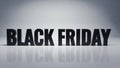 Black Friday text in bold letters on a reflective surface. The background is neutral, emphasizing the text. Ideal for Royalty Free Stock Photo