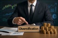 AI generated image of a businessman pointing at a Diversification nameplate. Surrounded by gold coins, financial documents, and Royalty Free Stock Photo