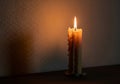 Single Lit Candle with Wax Drips and Steady Flame on Flat Surface Against Gradient Brown Background Royalty Free Stock Photo