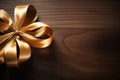 High angle view on the golden ribbon bow on a wooden table